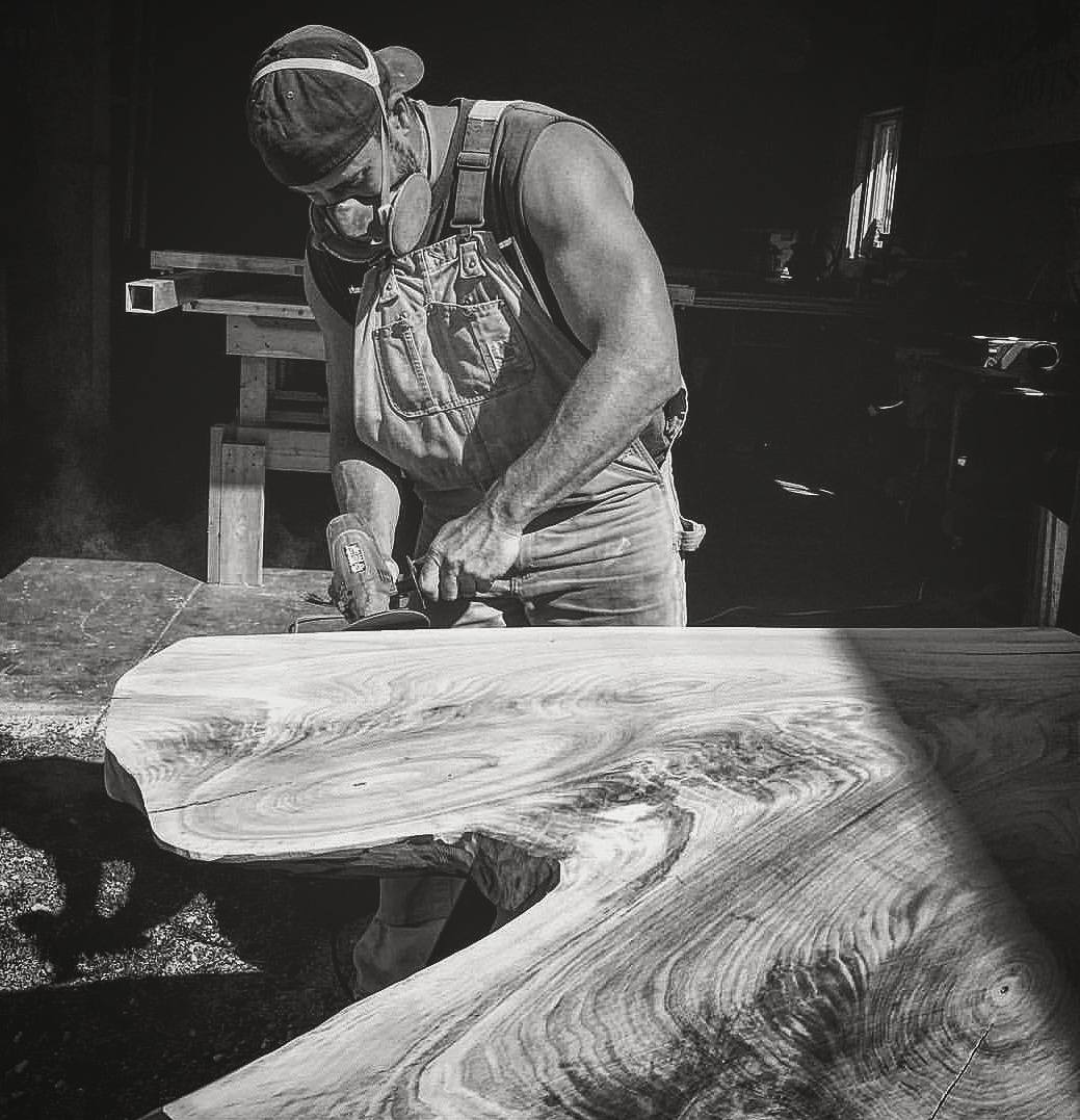 The maker hand-planing a live-edge slab at the bench