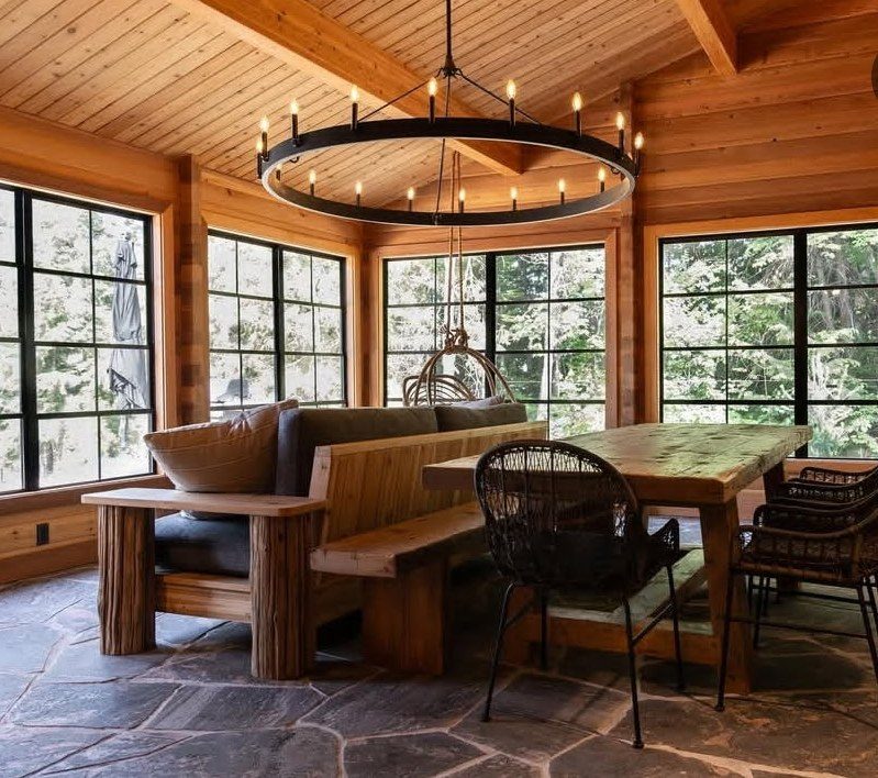 Rustic timber lounge bench and reclaimed-wood table in a cabin sunroom