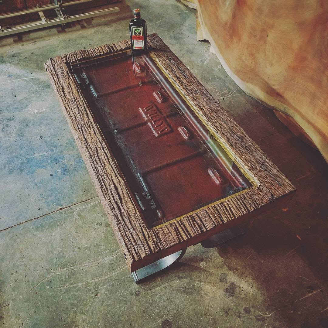 Coffee table built around a reclaimed Willys Jeep part under glass